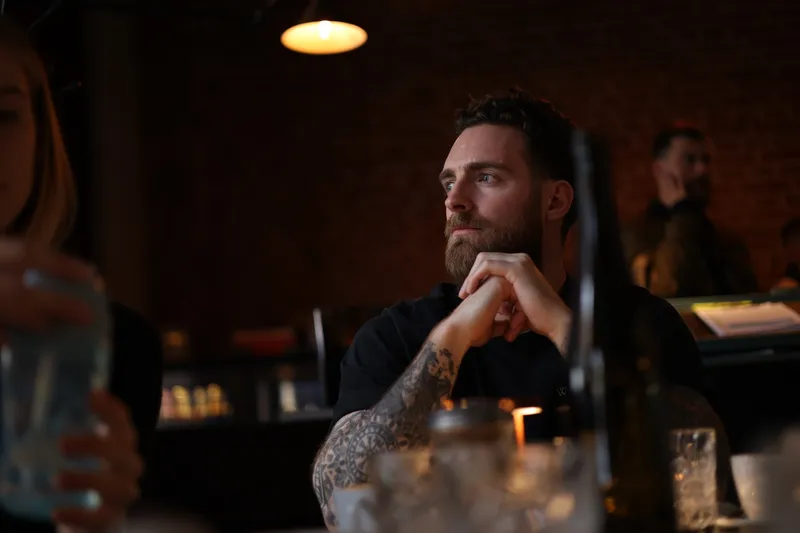 Michael Miller, founder of Requiq, listening at a table